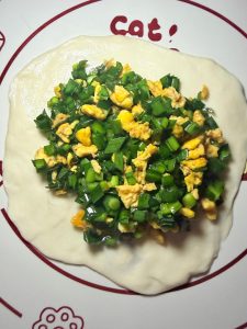 Place a generous amount of the chive and egg filling in the center and pinch the dough closed tightly.