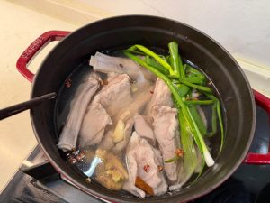 Add the washed lamb, the scallion, ginger and garlic to the pot, along with the Sichuan peppercorns and a small piece of cinnamon bark (which you can also leave out), pour in a lit