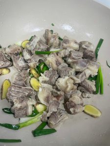 Heat a little oil in a wok, add the ginger and scallion and stir until fragrant, then add the parboiled beef brisket and toss for a few minutes.