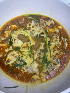 Pour in a generous amount of hot water, stir in the satay sauce and curry paste, and bring everything to a boil.