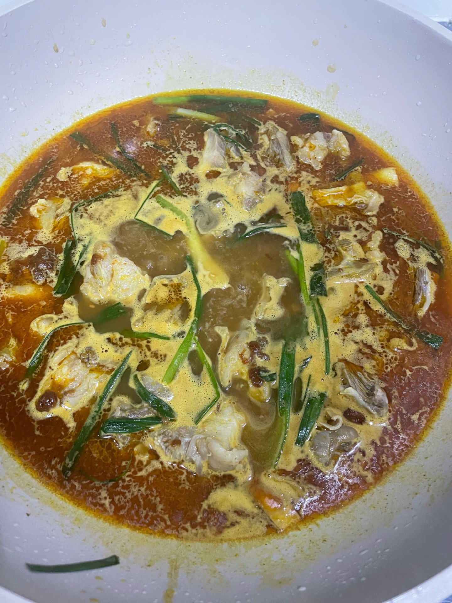 Pour in a generous amount of hot water, stir in the satay sauce and curry paste, and bring everything to a boil.