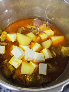 Open the lid and add the tofu and potato.