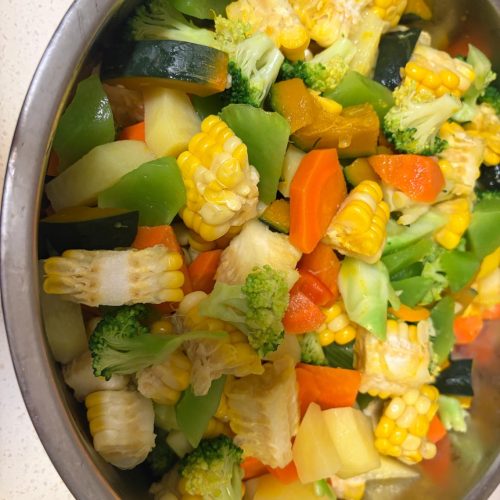 Blanched diet meal prep vegetables including corn, celtuce, carrot, kabocha, potato, broccoli and bell pepper arranged on a tray