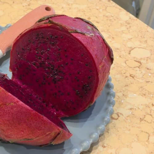 Pink dragon fruit cookies arranged on a plate