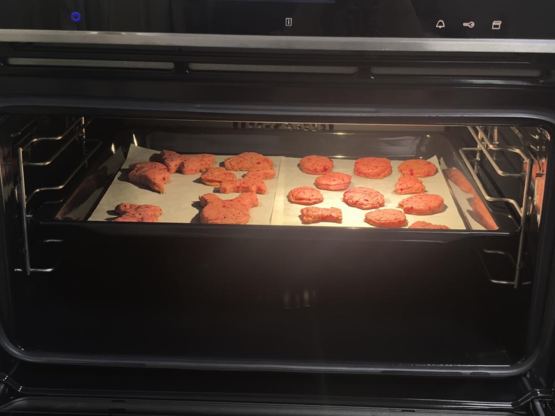 Tray of pink cookies going into the oven