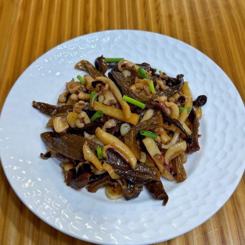 Dried cuttlefish stir-fry with velvet shank mushrooms in a wok