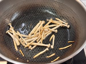Heat the wok with cold oil, add the seafood mushrooms and stir-fry until no moisture remains, then remove and set aside.