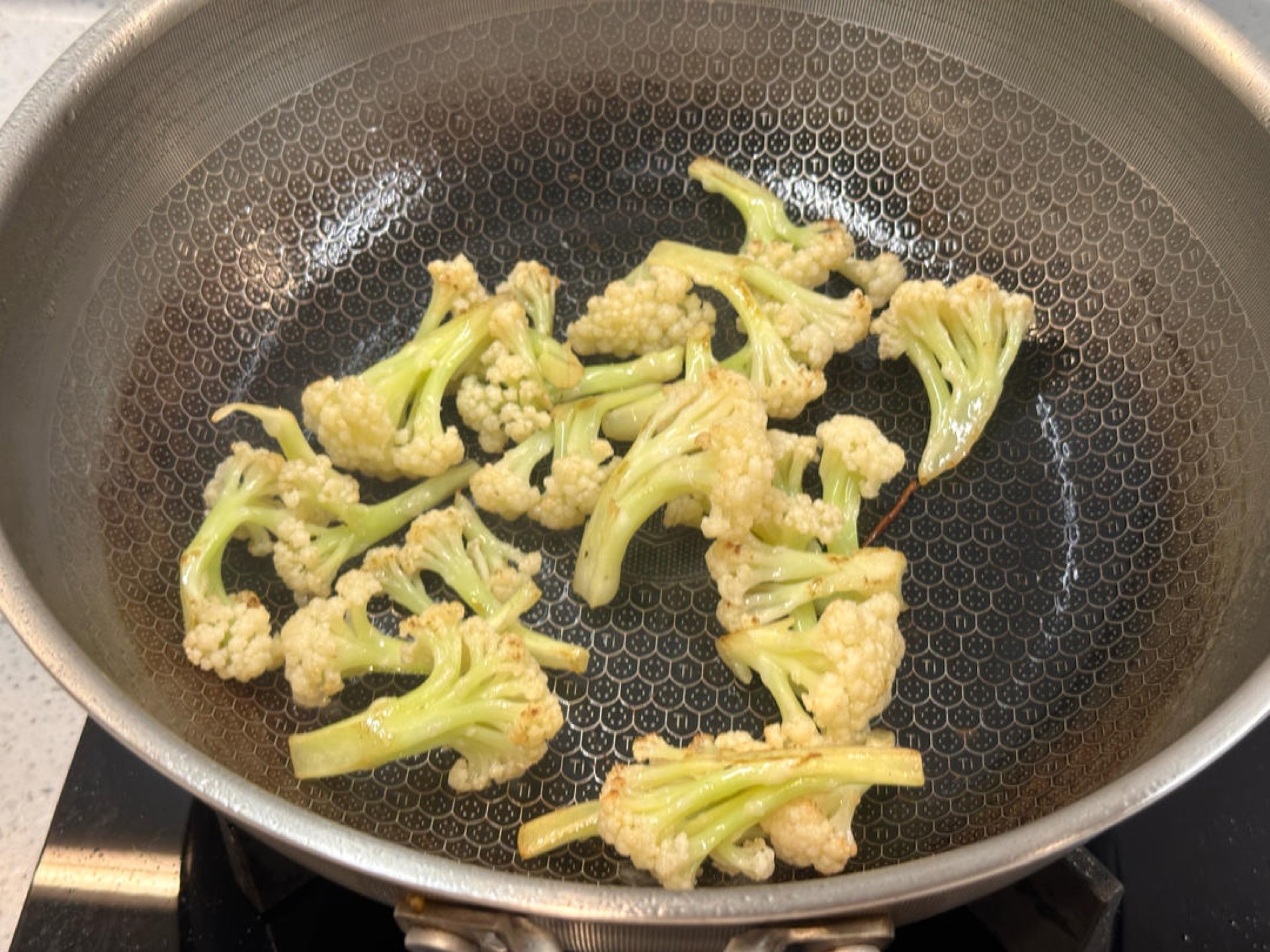Add a little more oil, add the cauliflower and stir-fry until no moisture remains, then return the cooked seafood mushrooms to the wok, add an appropriate amount of dry pot sauce,