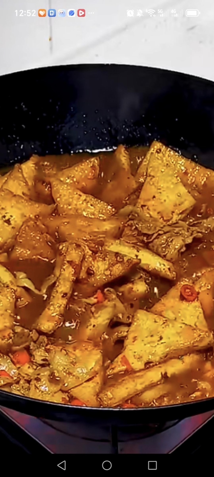 Add the fried tofu triangles back to the wok and simmer over medium-low heat for about 4 minutes, spooning the sauce over the pieces so they soak up the flavor.