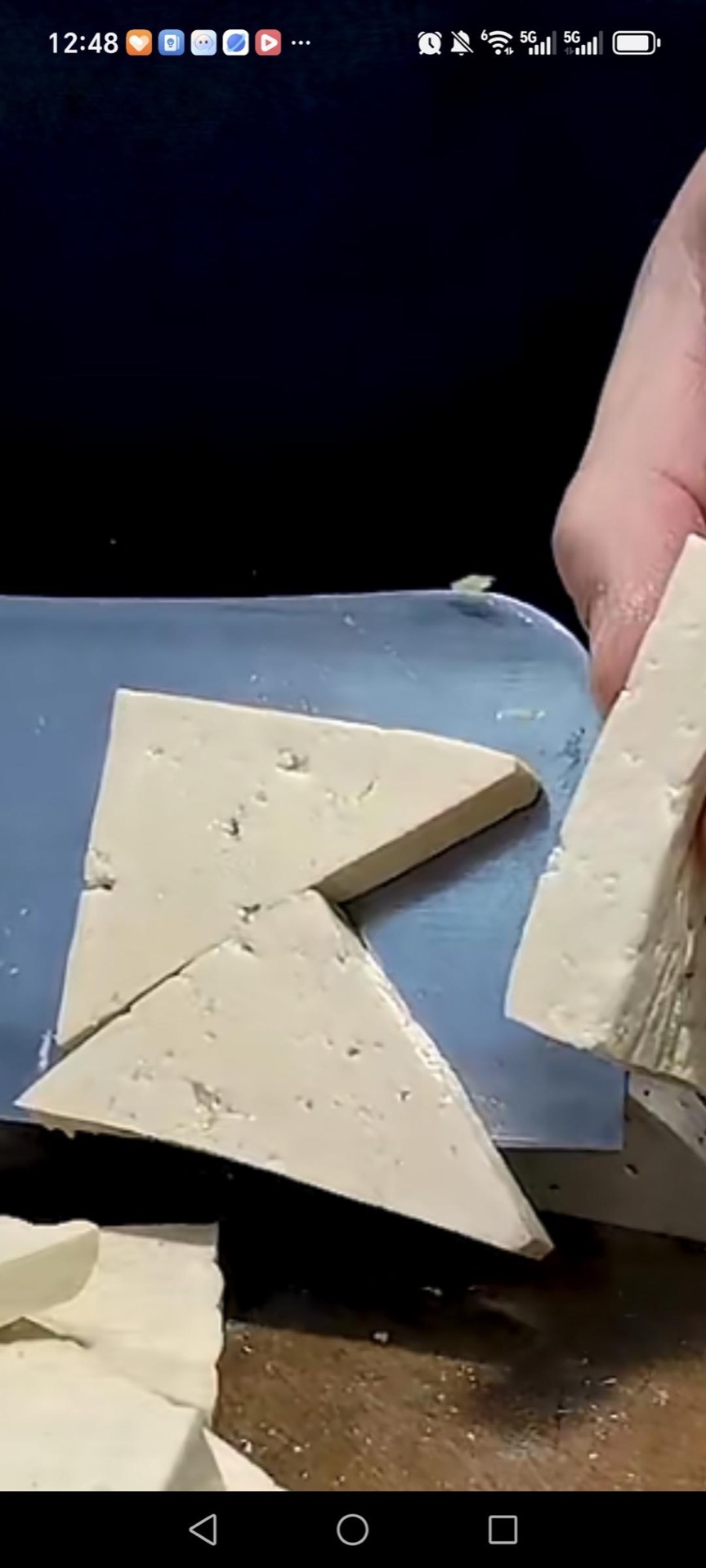 Cut each pressed slab on the diagonal into even triangular blocks so every piece has a flat face that will make good contact with the wok.