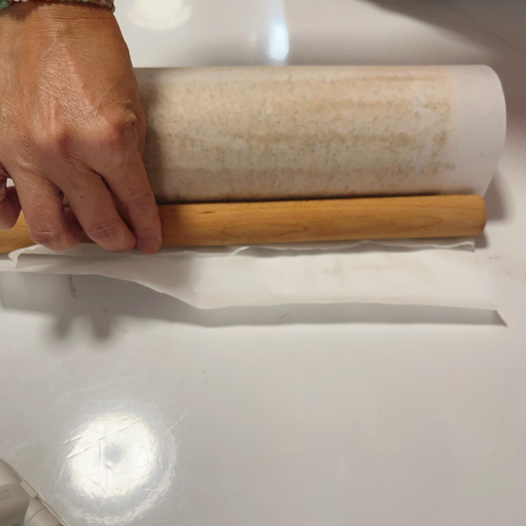 The cake being rolled tightly with the five-step method