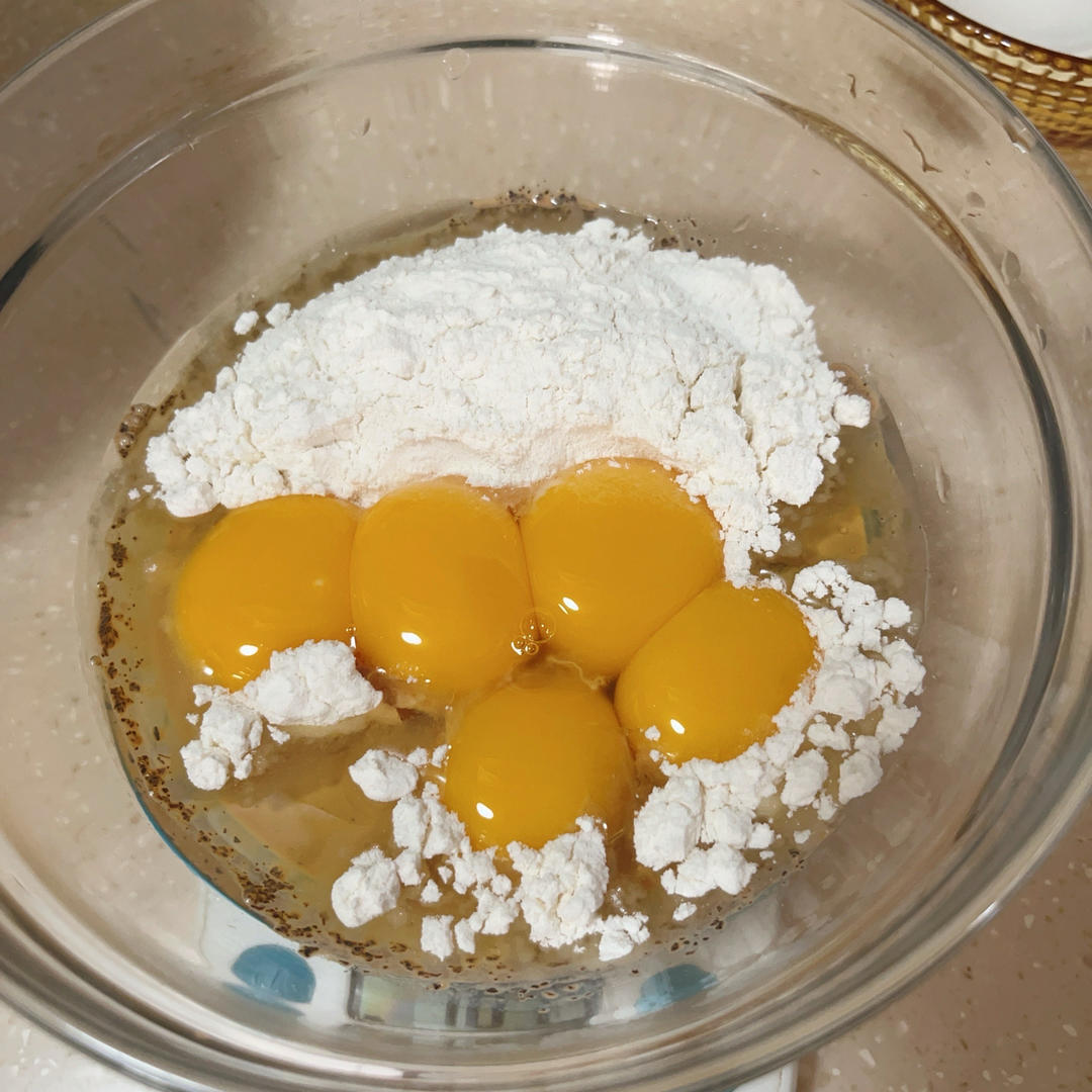 Tea milk oil flour and egg yolks combined in a bowl