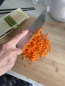 Peel the carrot and grate it on the fine side of a box grater, then run your knife through the shreds a few times so they are chopped fine and no long strands remain.
