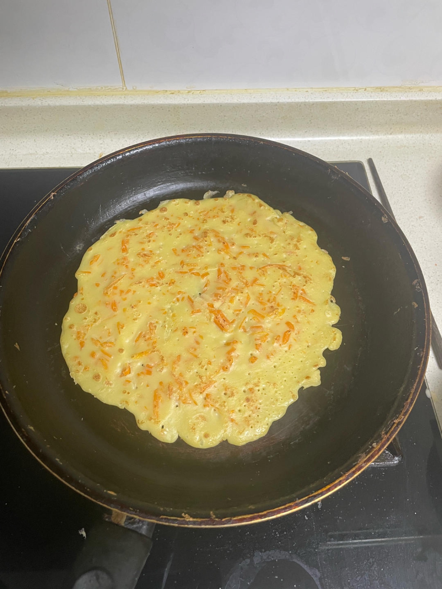 After about one minute the edges will lift and the surface will look dry and matte — slide a spatula under the pancake and flip it, then cook the second side for another 30 to 45 s