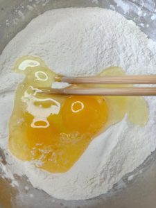Whisk flour salt sugar and yeast in a bowl then add eggs and warm water
