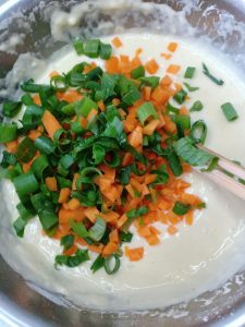 Check the rested batter for a honeycomb of bubbles then add carrot and scallion