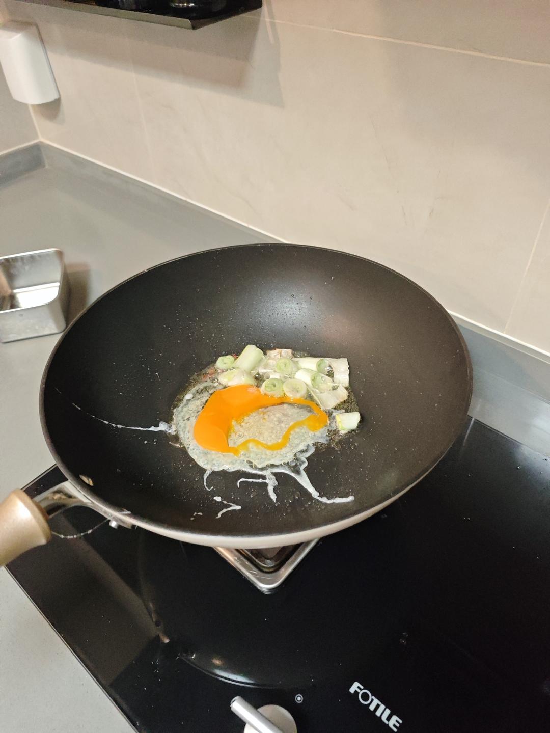 Two eggs being scrambled in the wok