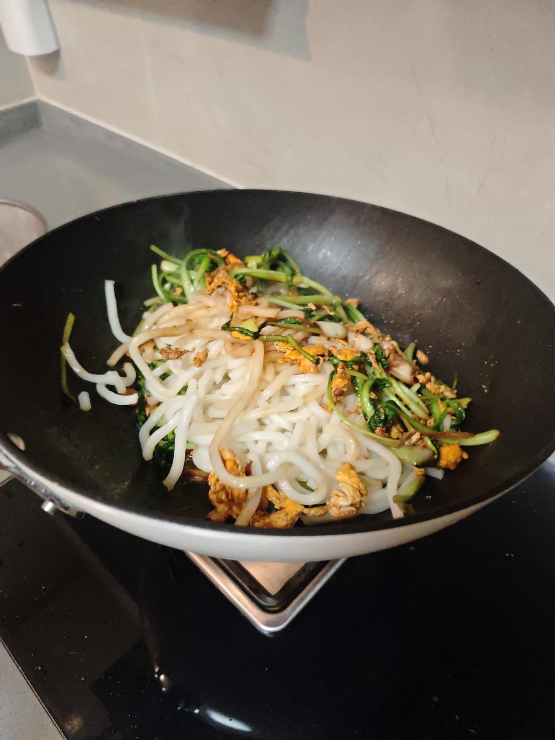 Pre-boiled udon noodles added to the wok