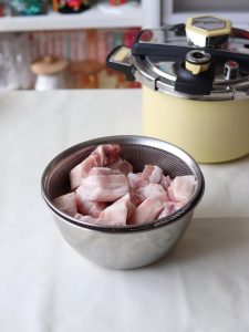 Cubes of skin-on pork belly on a cutting board