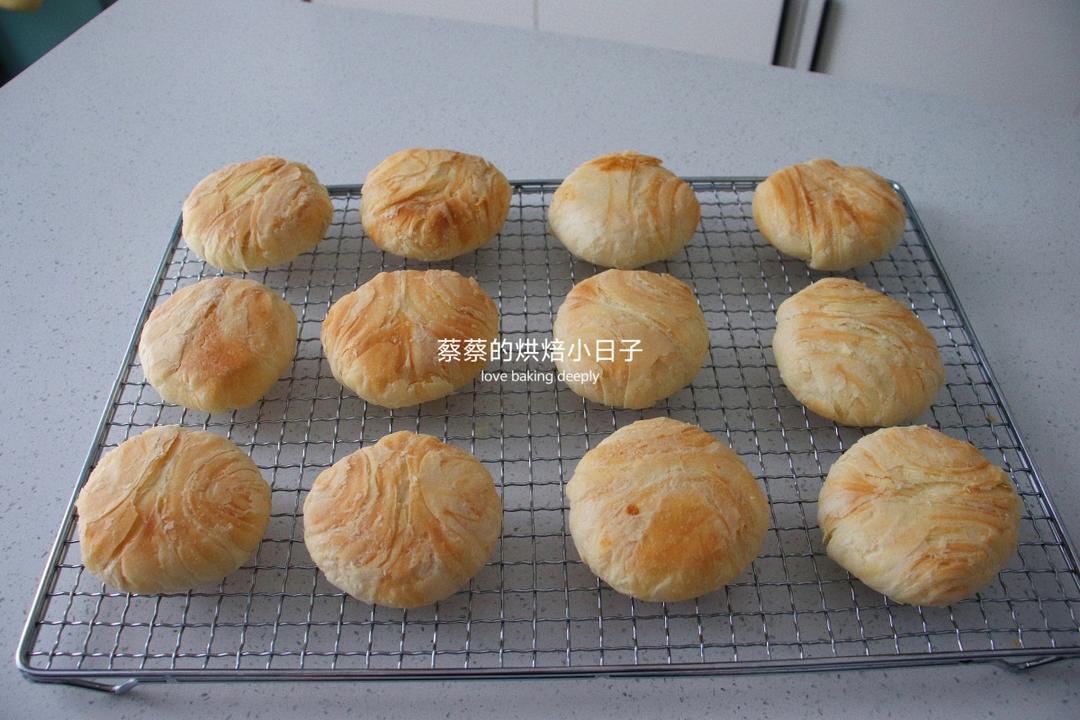Freshly baked flaky mooncakes cooling on the sheet