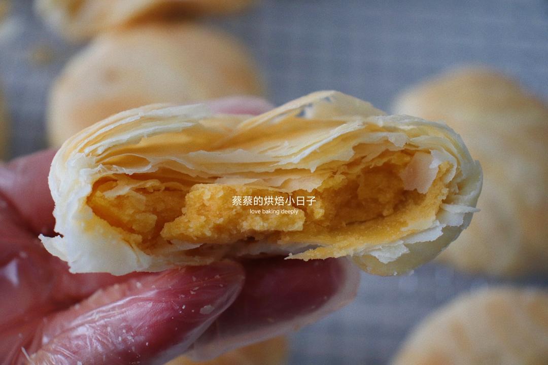 Close up of crumbly mooncake revealing the golden yolk filling
