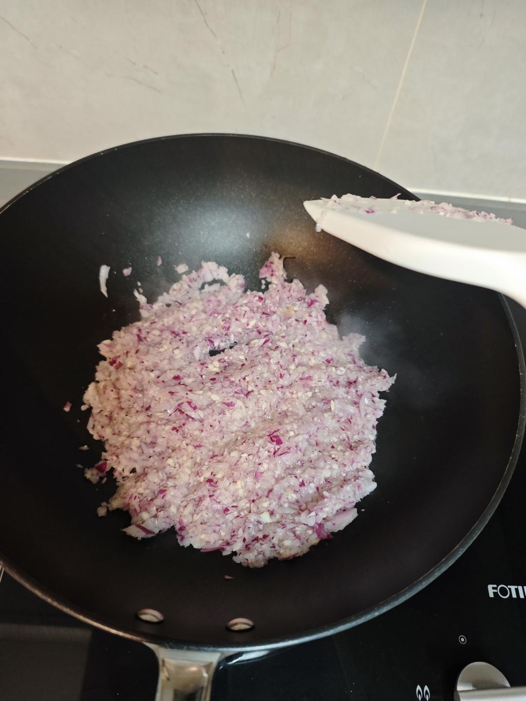 Onion and garlic frying in oil for the pizza sauce