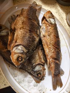 Fried crucian carp draining on a wire rack
