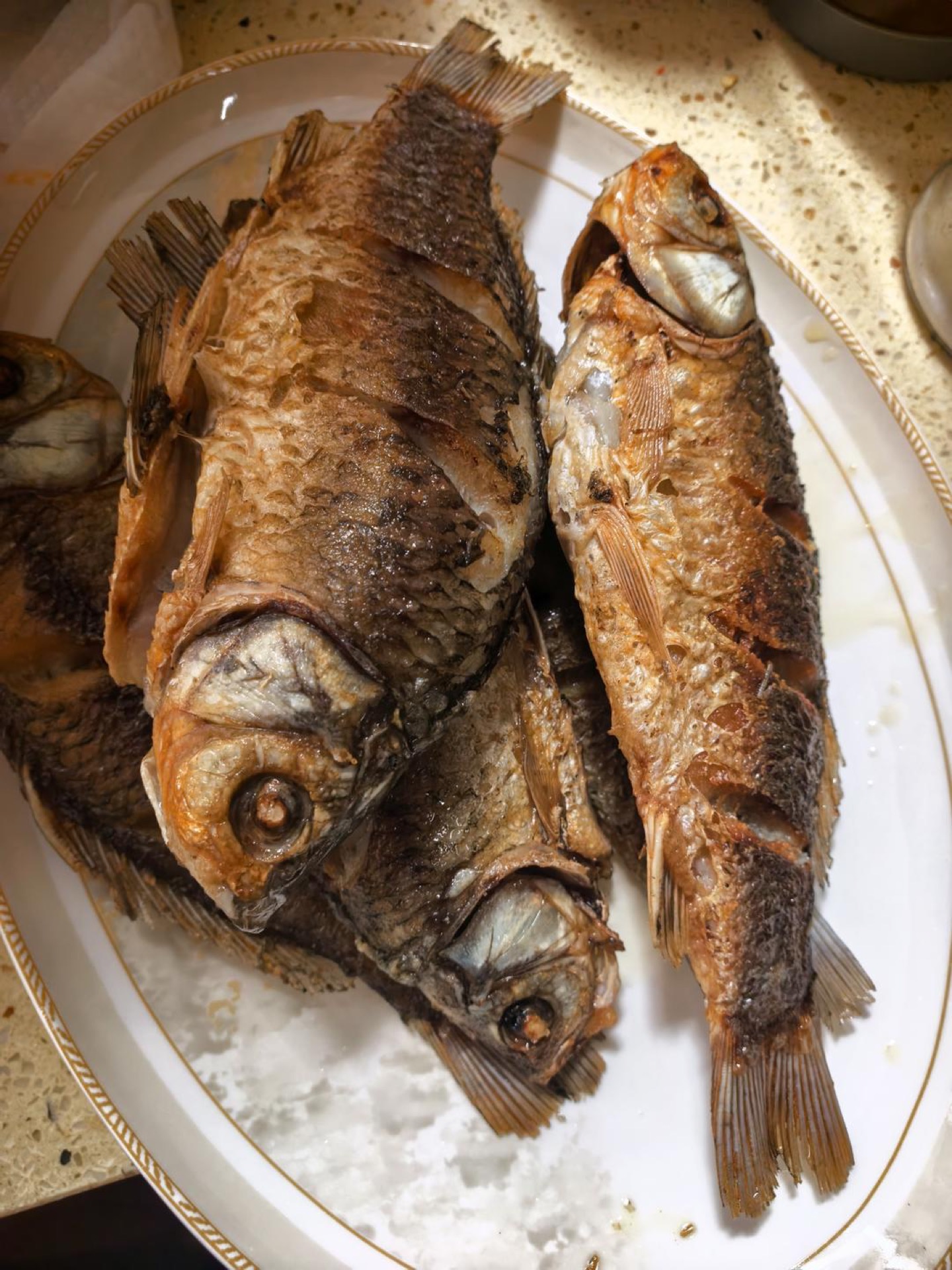 Fried crucian carp draining on a wire rack