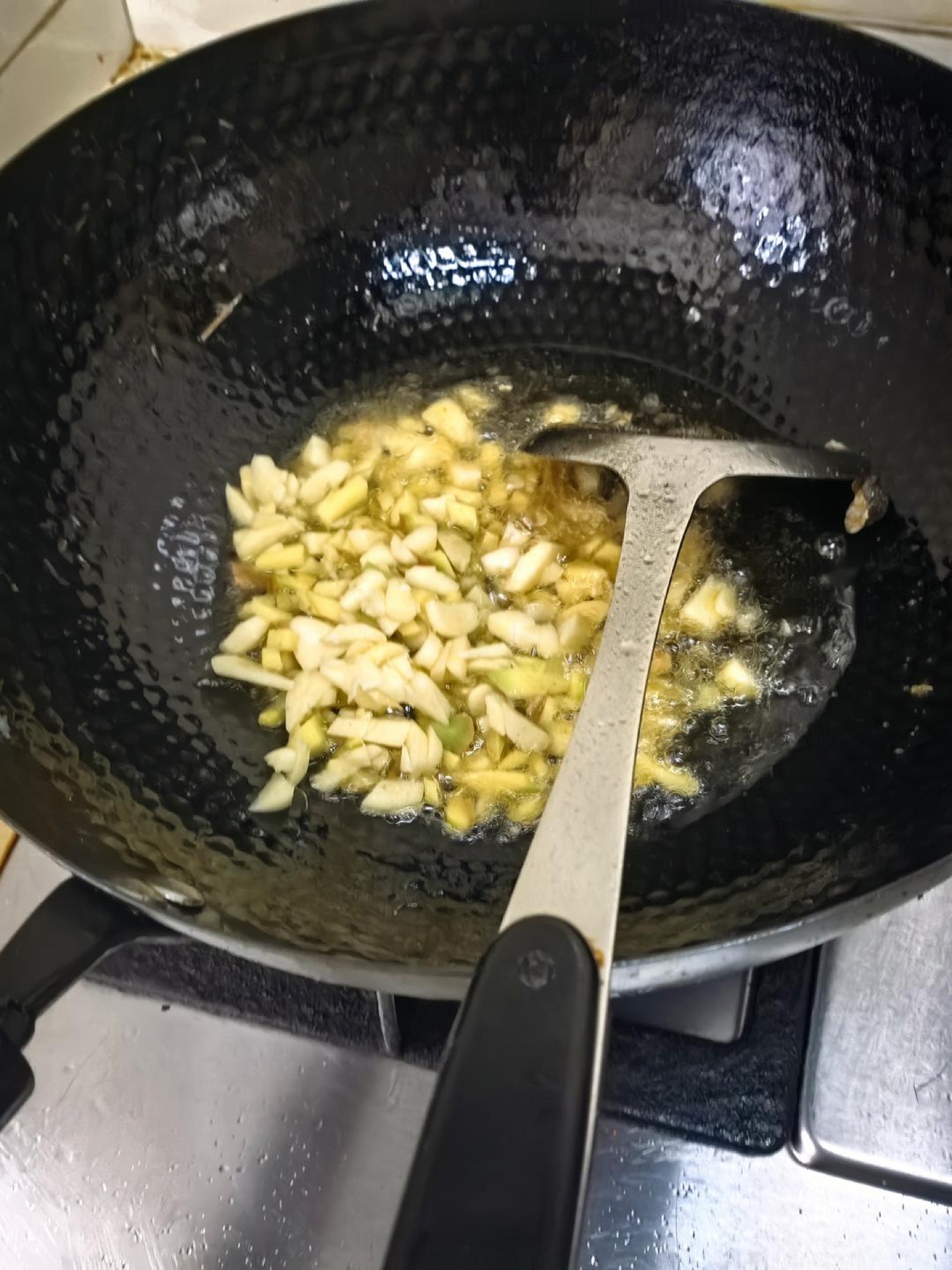 Ginger, garlic, and chili flakes blooming in a wok