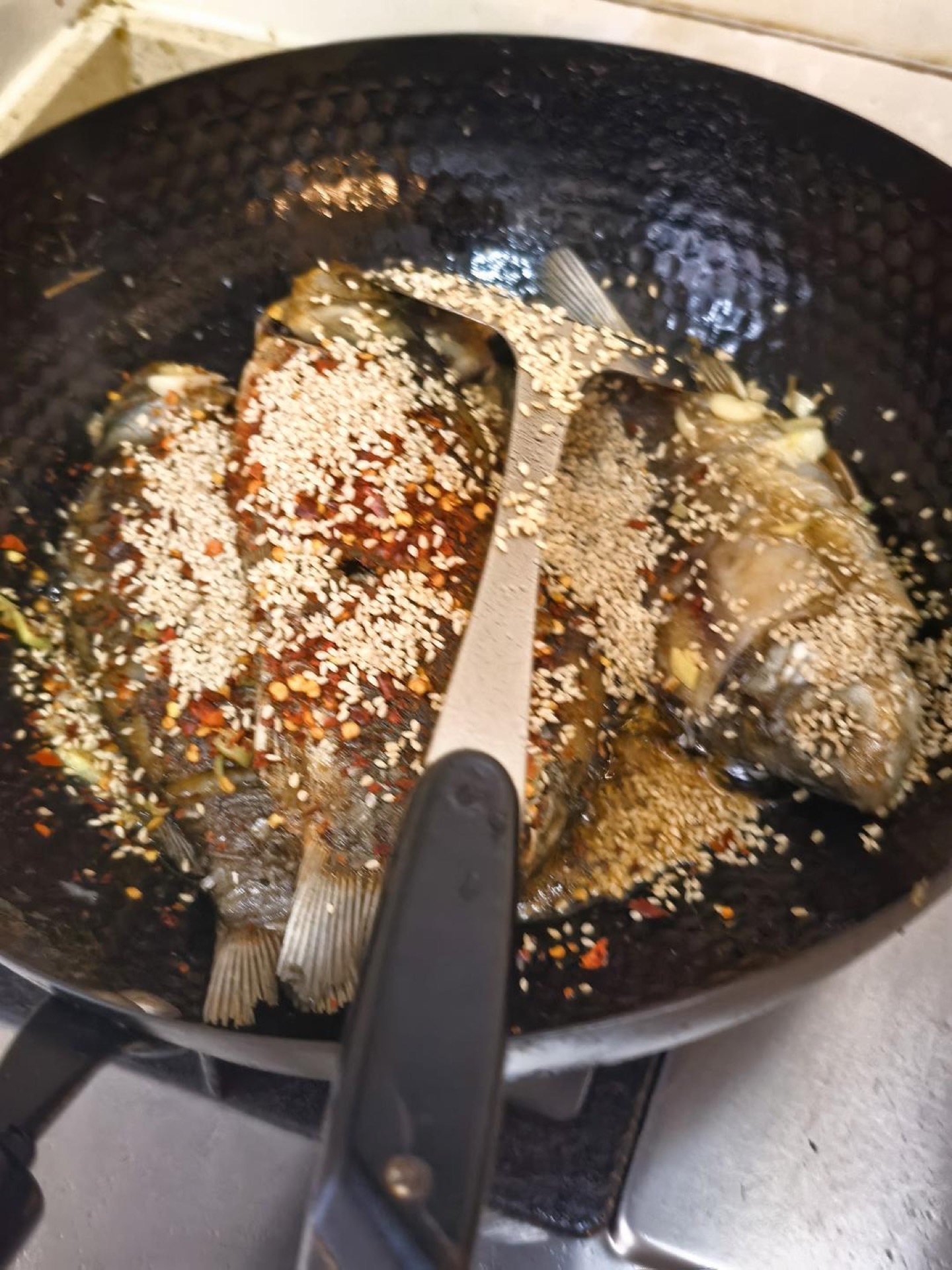 Fried fish returned to the wok with aromatics