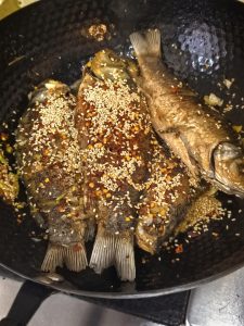 Soy sauce being drizzled around the edge of the wok