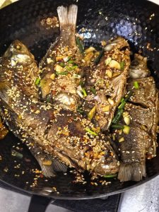 Scallions and sesame scattered over the fried fish
