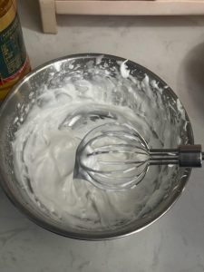 Egg white being whipped to stiff glossy peaks