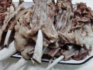 Lamb rack simmering in the pot with orange peel tsao-ko and aromatics