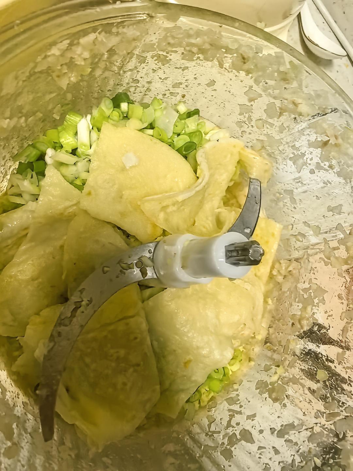 Let the pancakes cool, cut them into large pieces, then grind them together with the scallions, ginger, and pork belly to a coarse, granular texture.