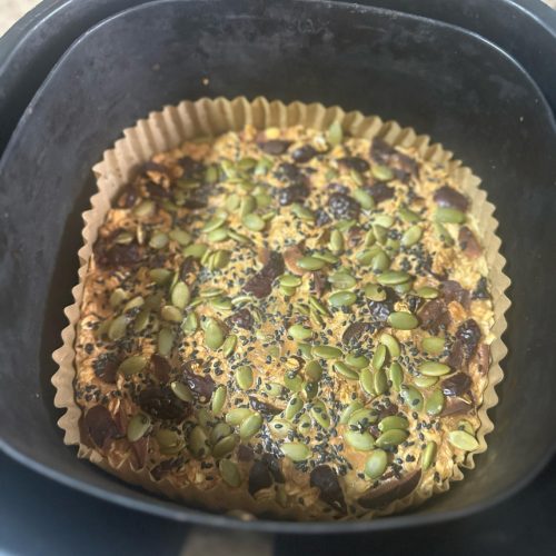 Healthy oat red date cake sliced on a plate with raisins and black sesame on top