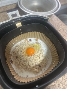 Oat, milk, egg, and date mixture stirred together in a bowl