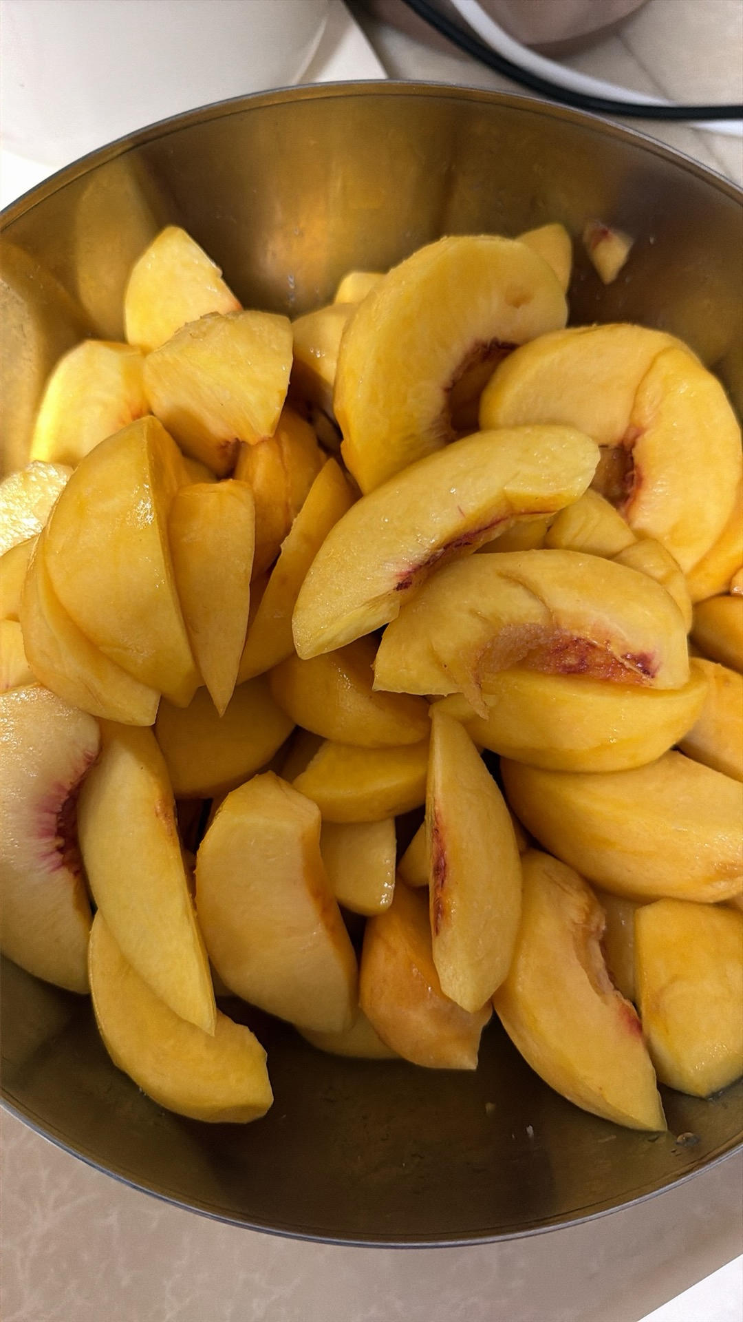 Yellow peaches being cut into wedges around the pit