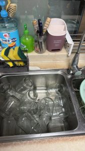 Glass jars and lids being scalded in boiling water