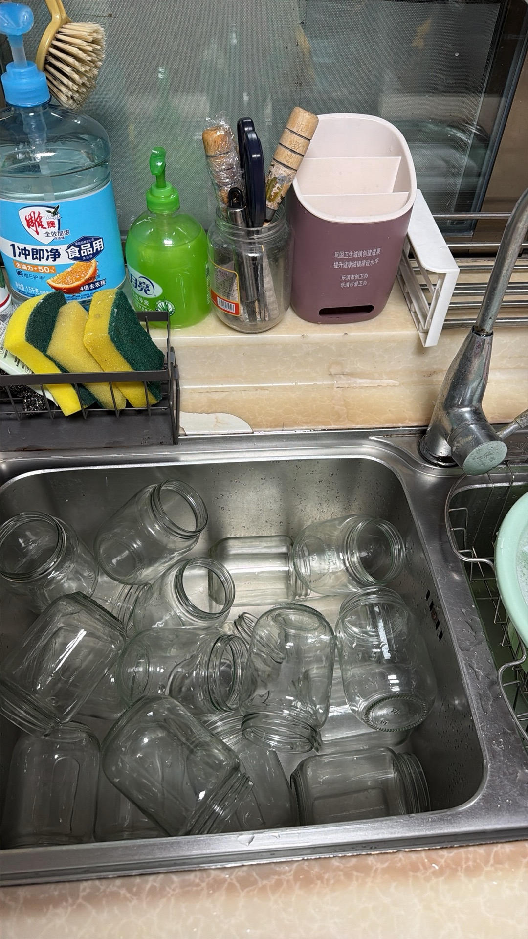 Glass jars and lids being scalded in boiling water