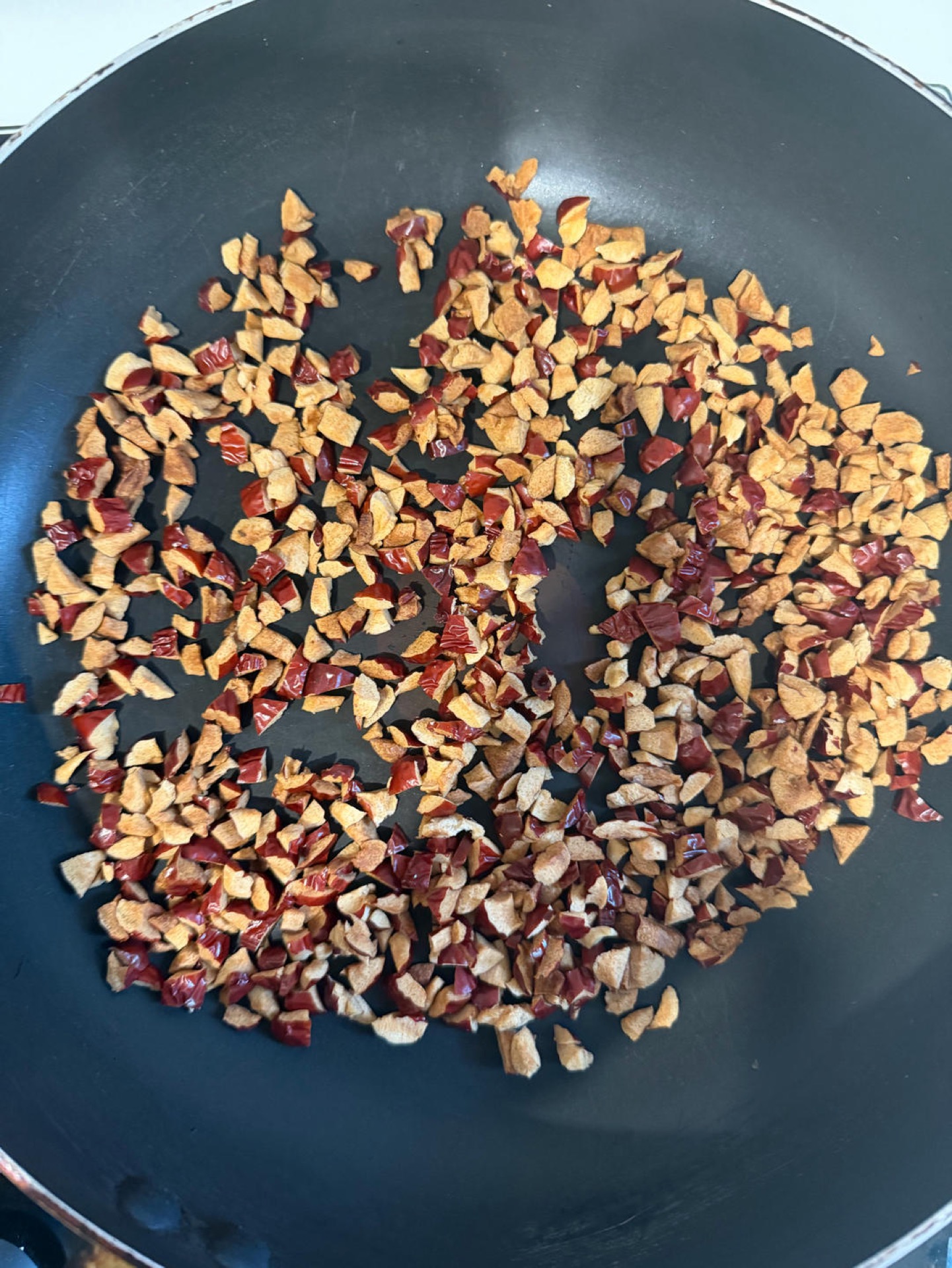 Toasting chopped red dates in a skillet