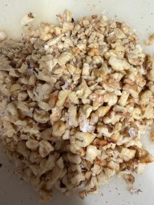 Toasted walnuts being crushed with a rolling pin