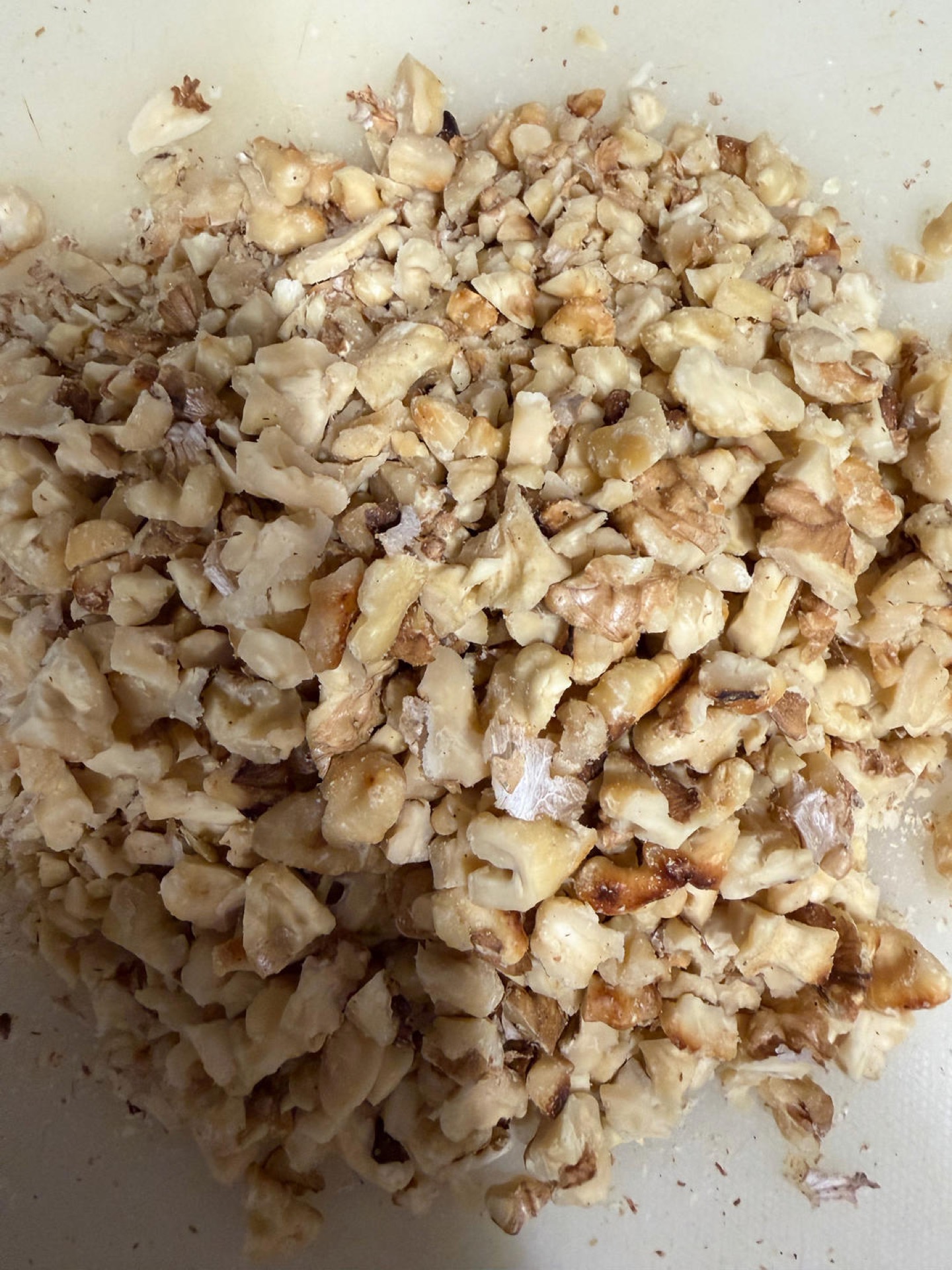 Toasted walnuts being crushed with a rolling pin