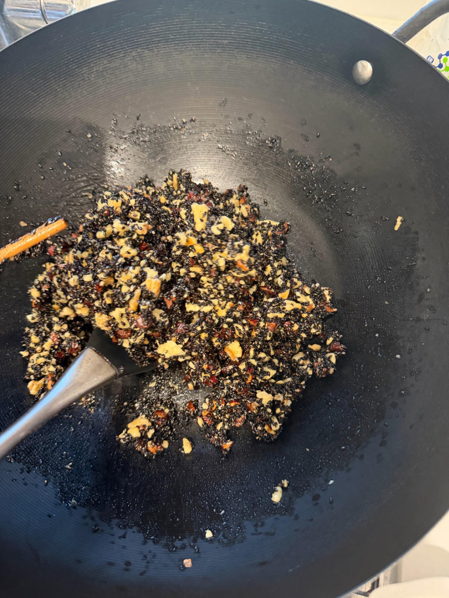 Stirring the honey-coated sesame mixture in a pan