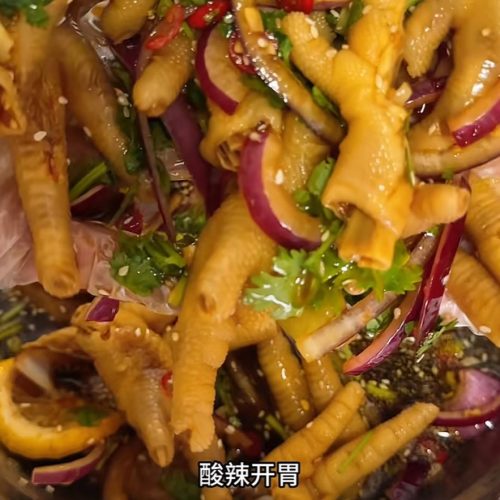 Hot and sour chicken feet (酸辣鸡爪) in a bowl, tossed with chile, garlic, lime and sesame seeds