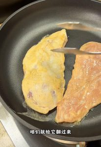 Water-steamed chicken cutlets in a covered pan with steam rising