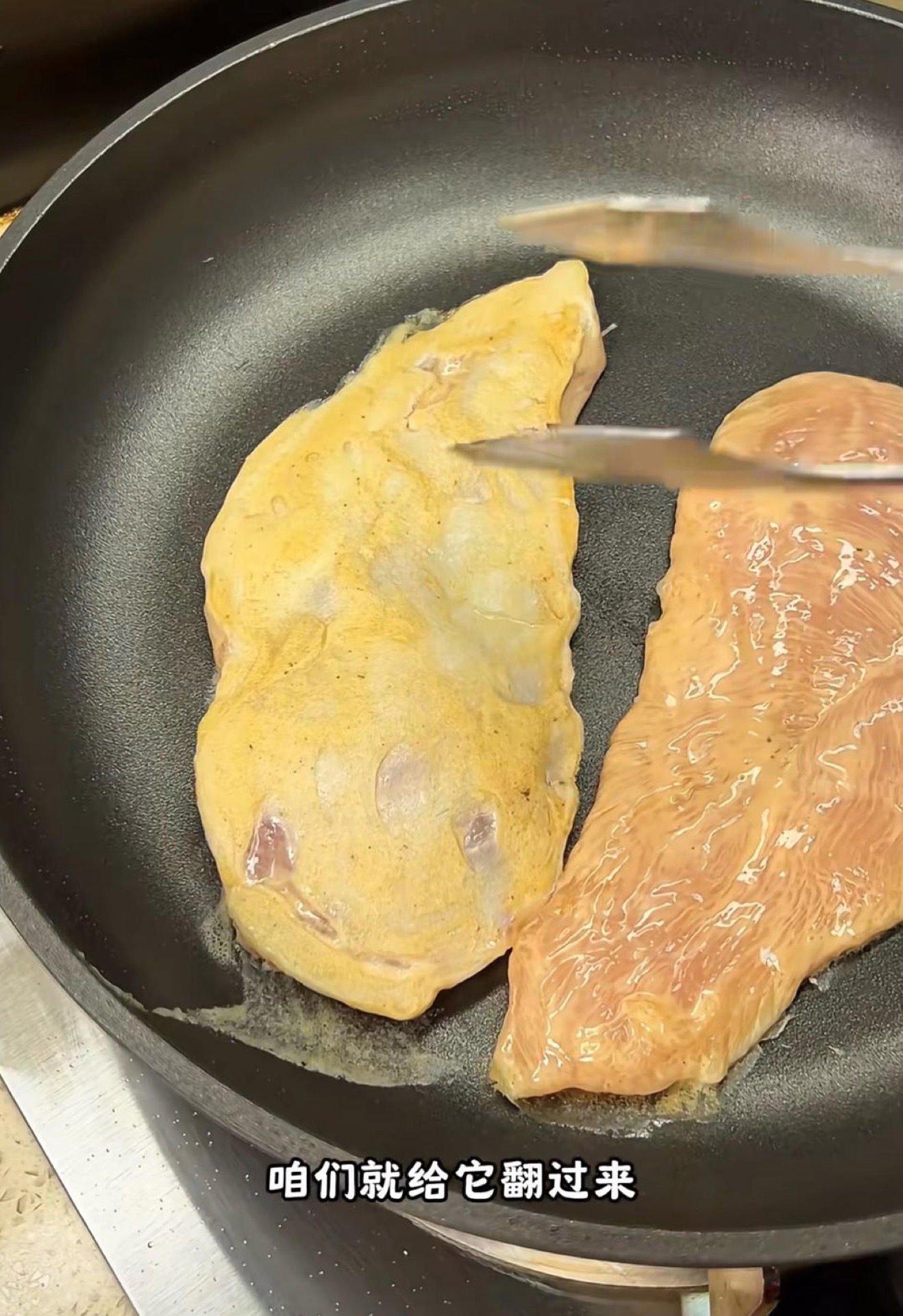 Water-steamed chicken cutlets in a covered pan with steam rising