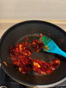 Soy sauce being stirred into the chili base
