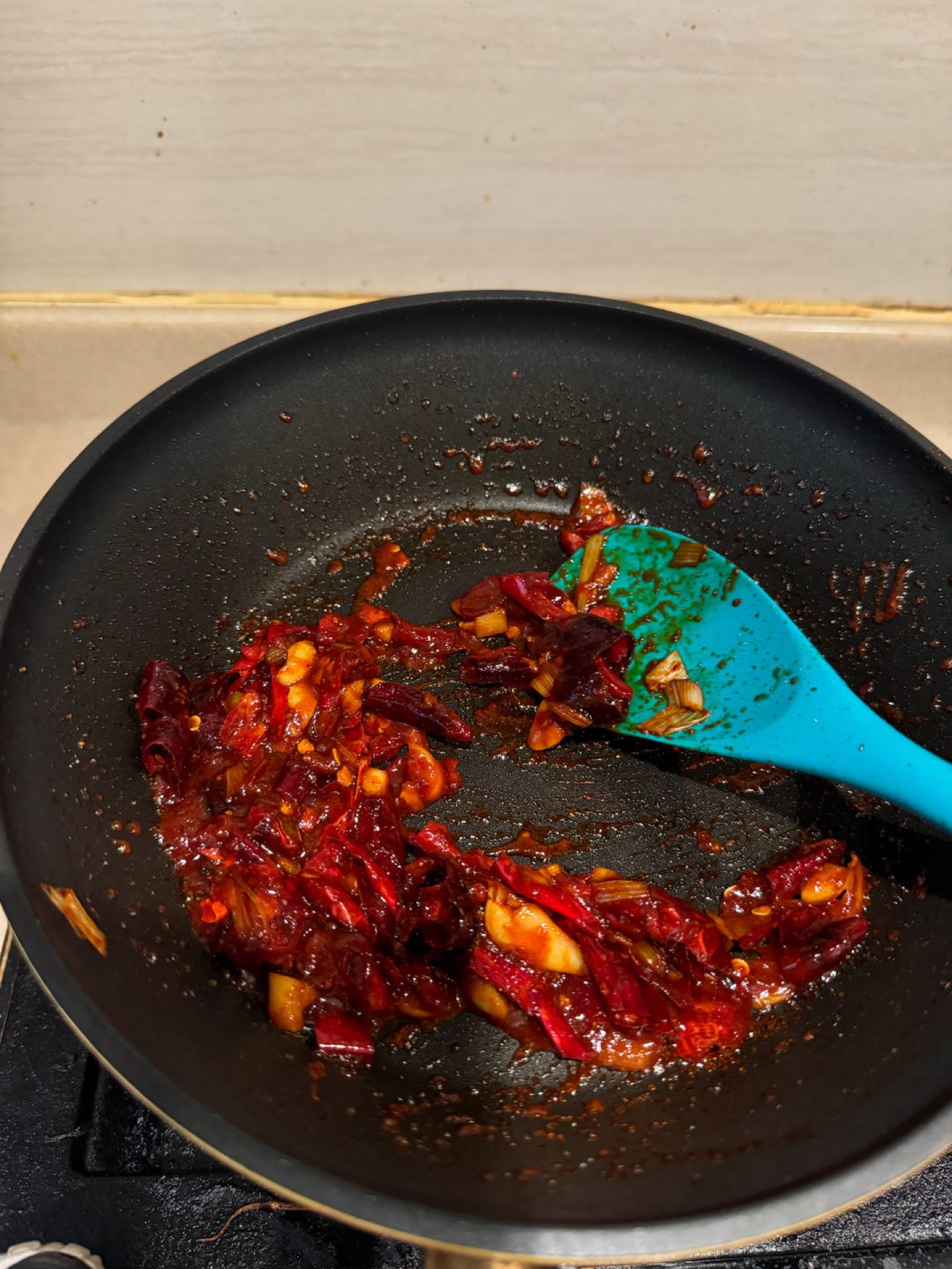 Soy sauce being stirred into the chili base