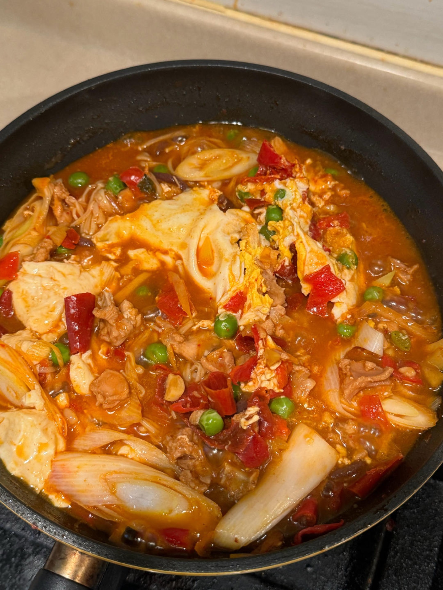 Finished Korean spicy rabbit tofu soup with scallions and red chili